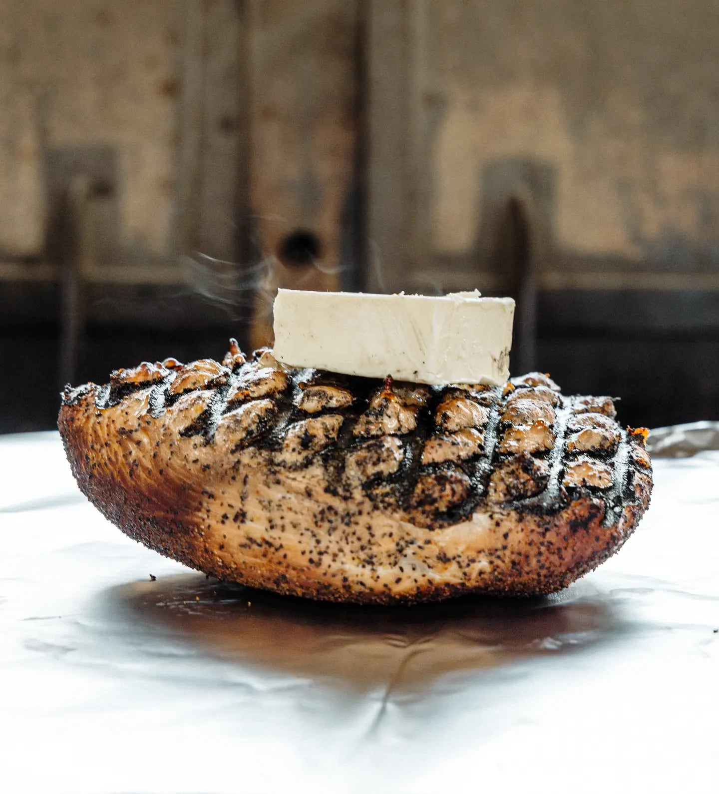 A loaf of house-baked bread with a pat of butter melting on top