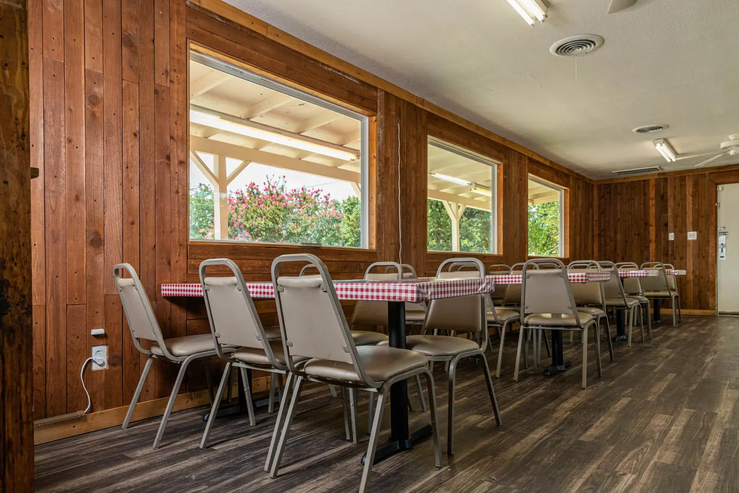 Goldee's dining room, gingham-topped tables and metal chairs in a wood-panelled room lit by its windows