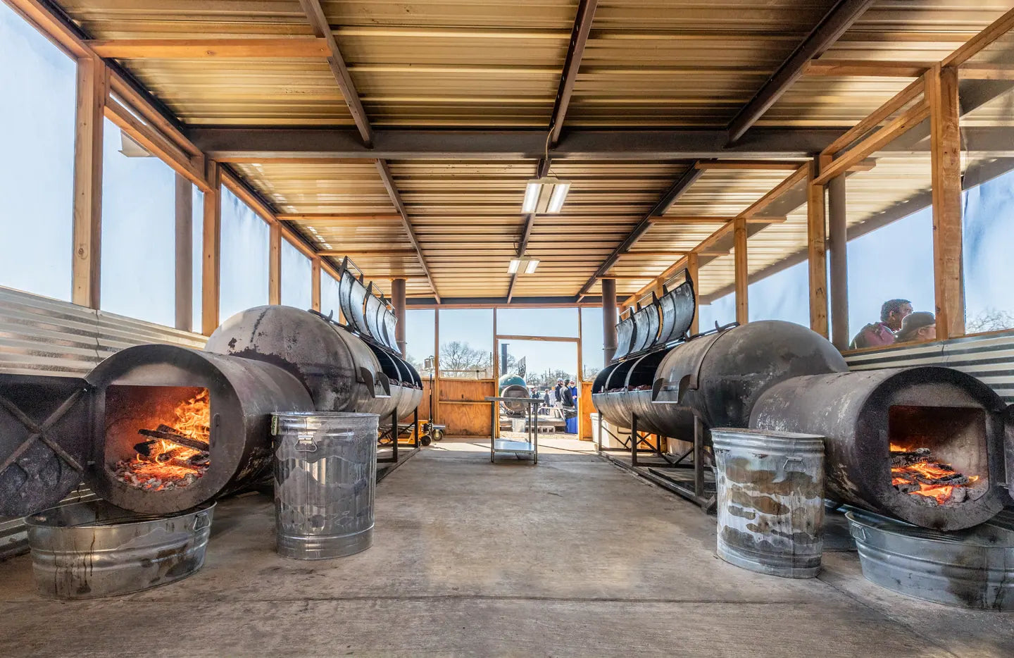 The pit alley at Goldee's, offset smokers down both sides with their fireboxes lit