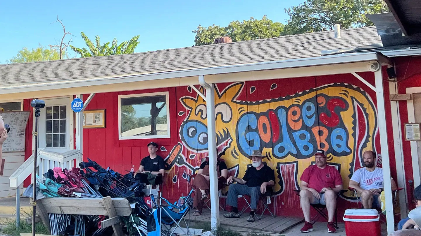 Customers sitting in lawn chairs under the porch outside Goldee's